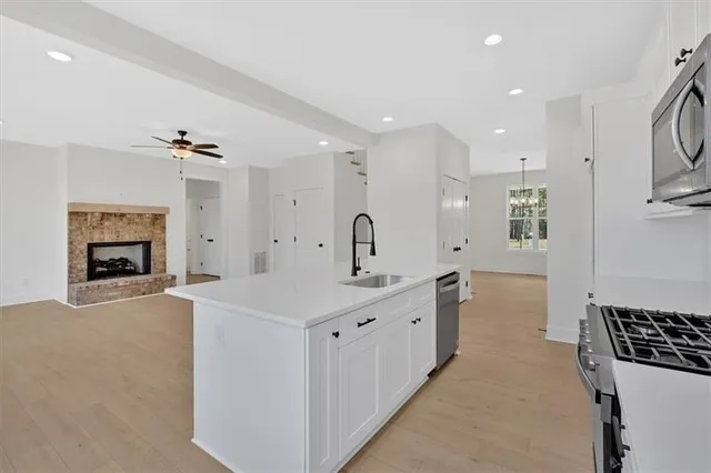 a large white kitchen with a sink a stove and a refrigerator