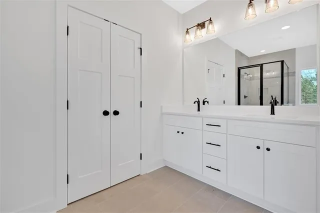 a bathroom with a double vanity sink mirror and shower