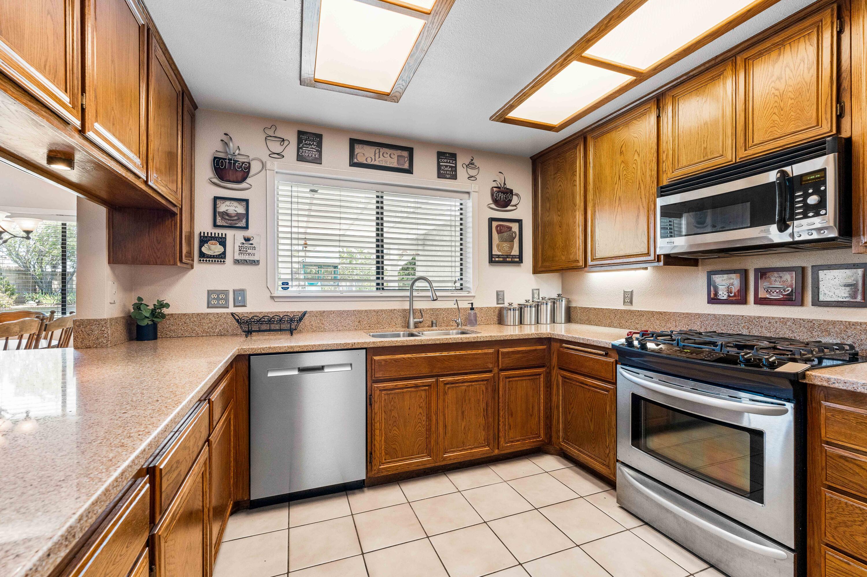 6311 West Ave L12 Lancaster, CA 93536 - Photo 13 of 55 a kitchen with stainless steel appliances granite countertop wooden cabinets a sink and a stove