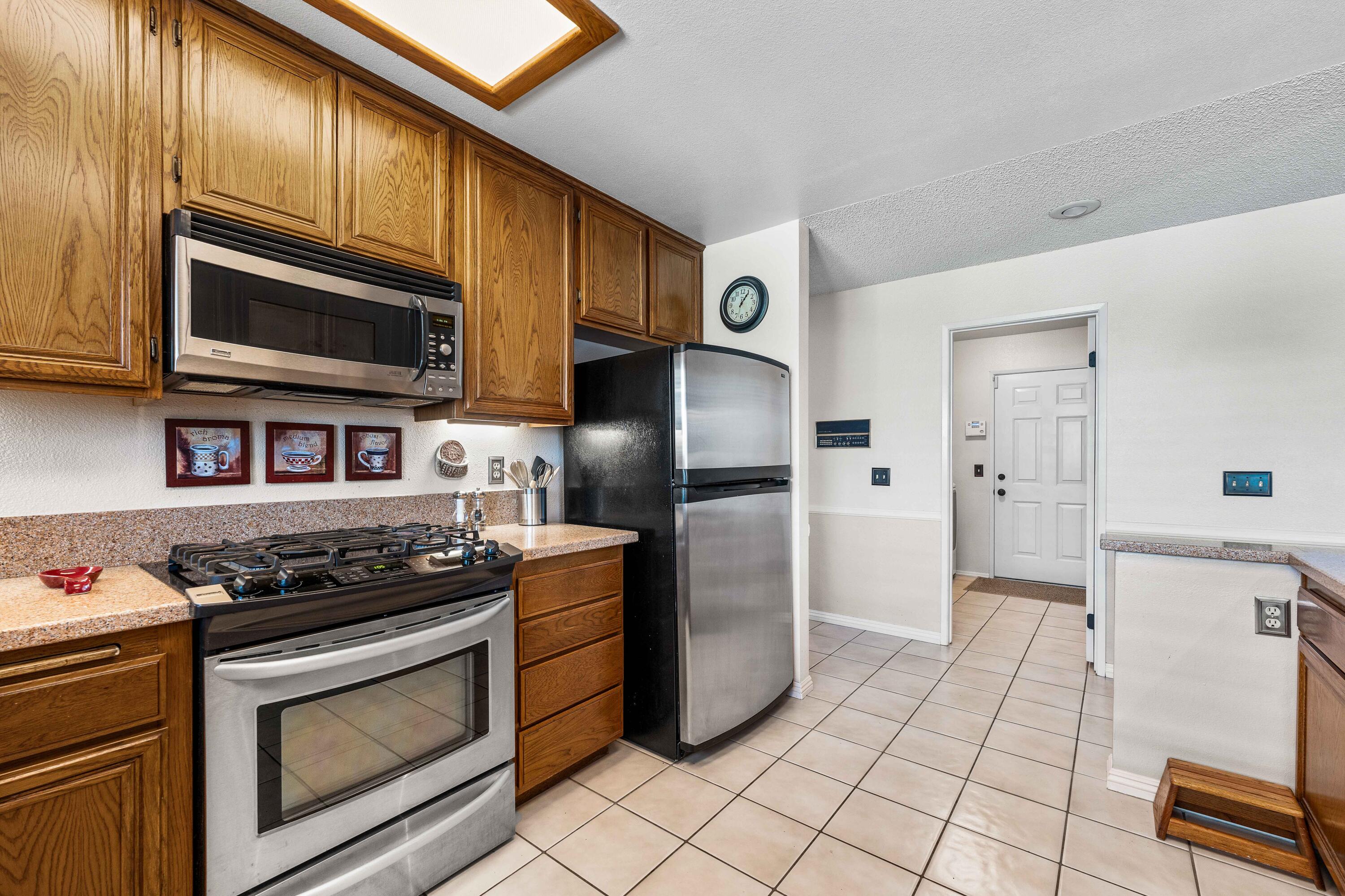 6311 West Ave L12 Lancaster, CA 93536 - Photo 14 of 55 a kitchen with stainless steel appliances granite countertop a stove a microwave and a refrigerator