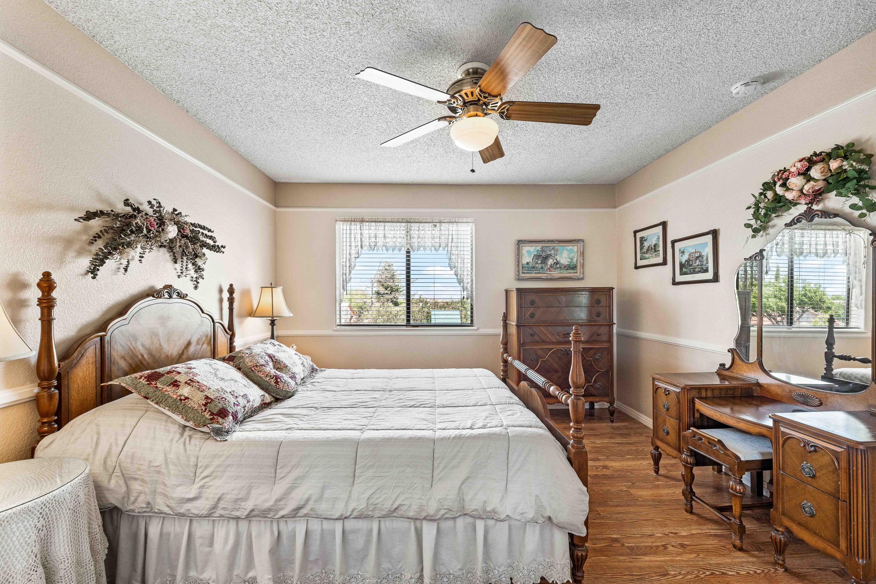 6311 West Ave L12 Lancaster, CA 93536 - Photo 26 of 55 a bedroom with a large bed a flat tv screen and a dresser