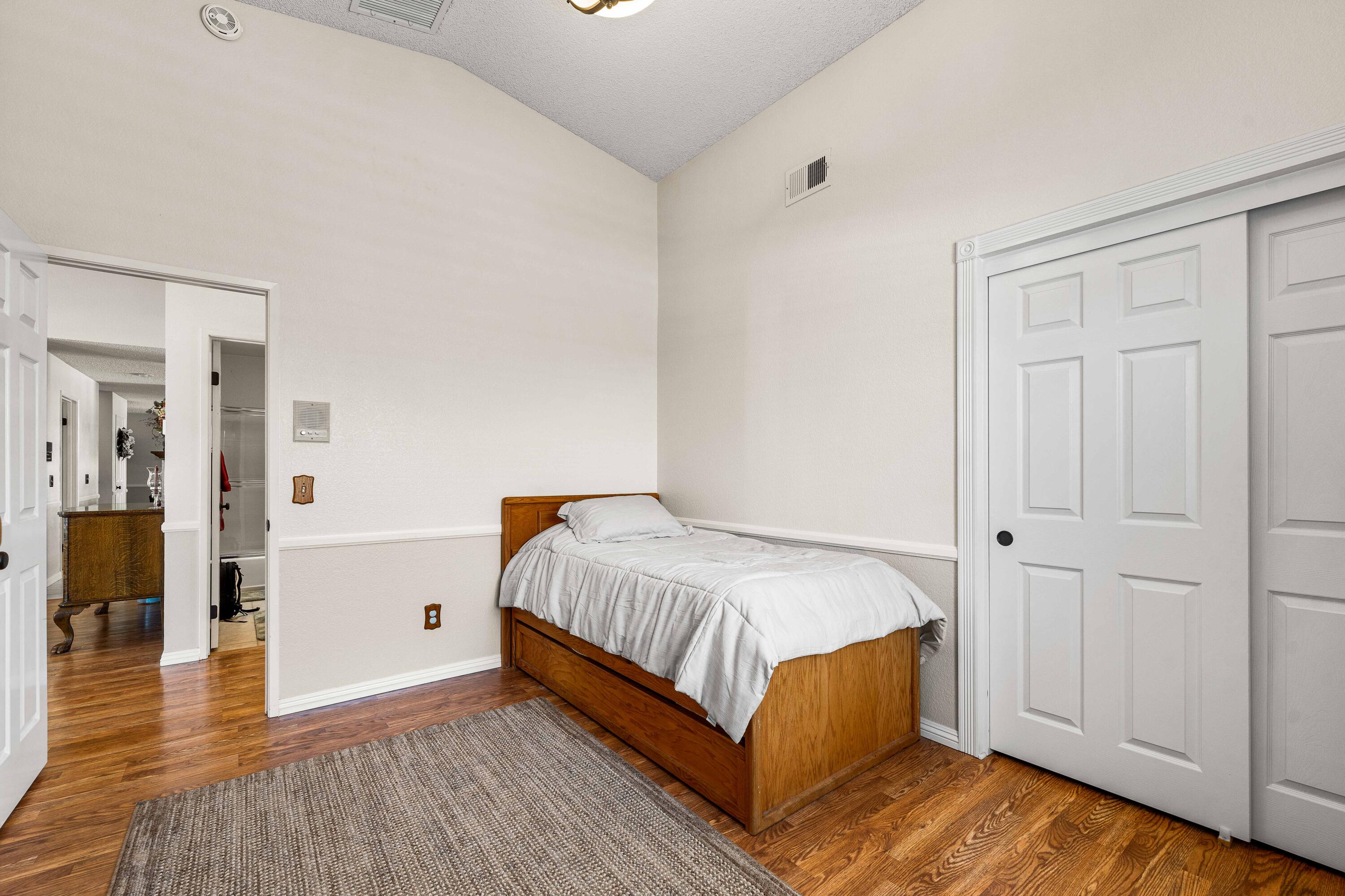 6311 West Ave L12 Lancaster, CA 93536 - Photo 33 of 55 a bedroom with a bed and wooden floor