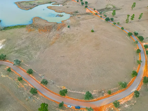an aerial view of a house with a yard and lake view