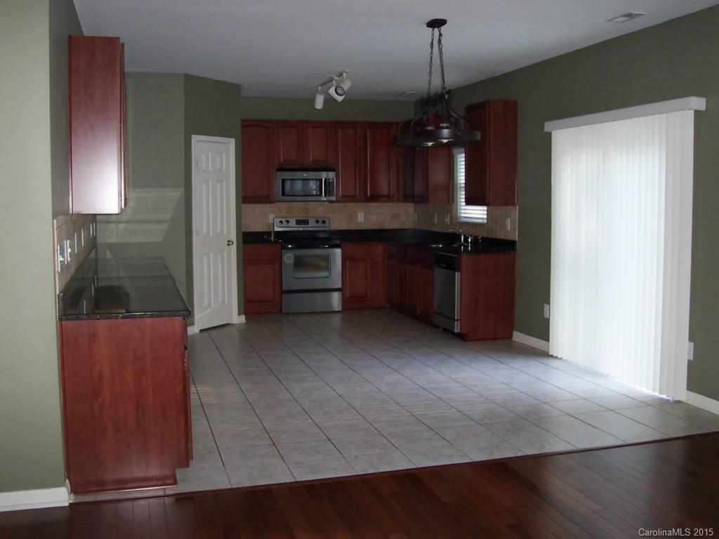 1135 Spicewood Pines Road, Unit 15 Fort Mill, SC 29708 - Photo 4 of 15 a kitchen with stainless steel appliances granite countertop a stove a refrigerator and a wooden cabinets
