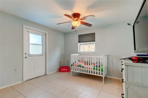 a view of a room with a window and chandelier fan