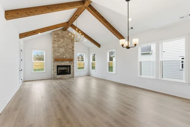 a view of empty room with wooden floor fireplace and windows