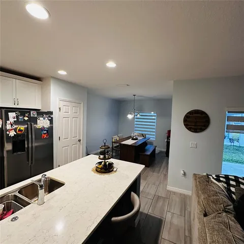 a kitchen with a sink a stove and chairs