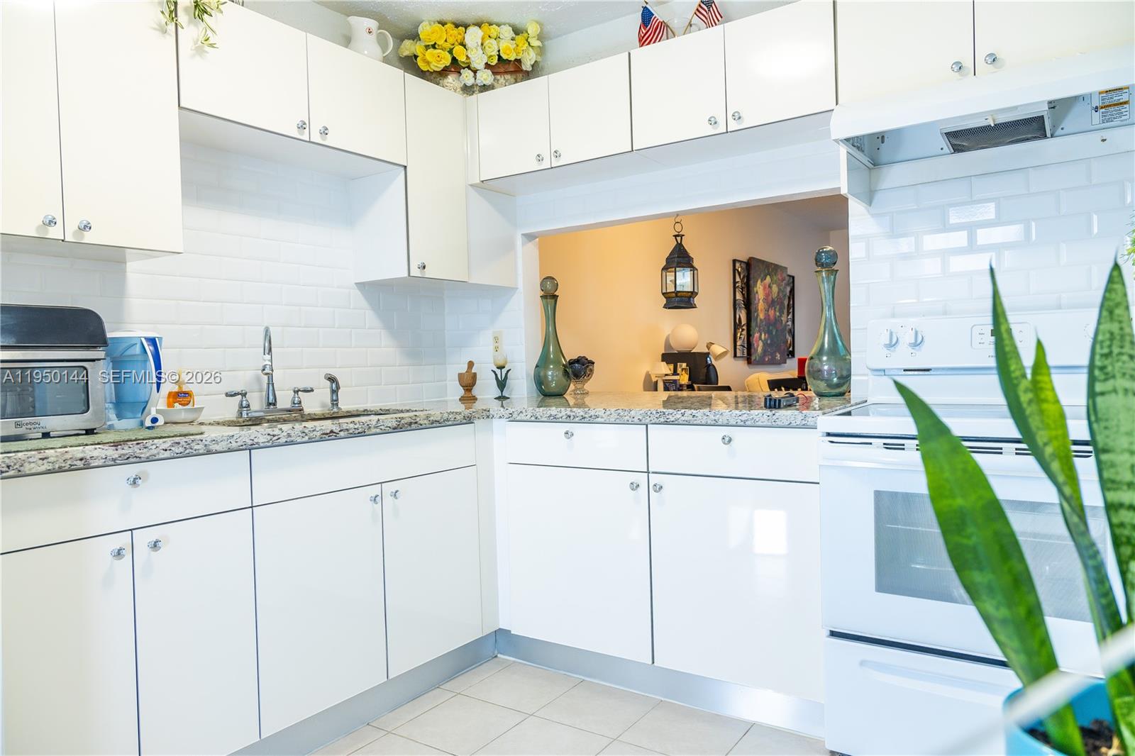 a kitchen with granite countertop white cabinets and white appliances