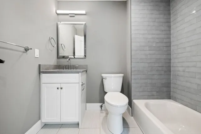 a bathroom with a toilet a sink a mirror and bathtub