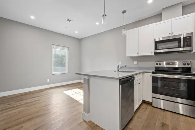 a kitchen with stainless steel appliances granite countertop a stove a sink and a microwave