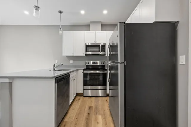a kitchen with stainless steel appliances a refrigerator and a stove top oven