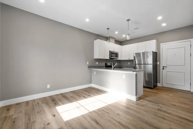 a kitchen with stainless steel appliances a refrigerator sink and microwave