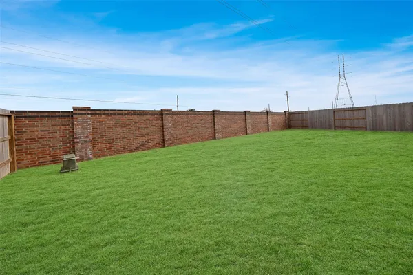 a view of a backyard with couches plants and large tree