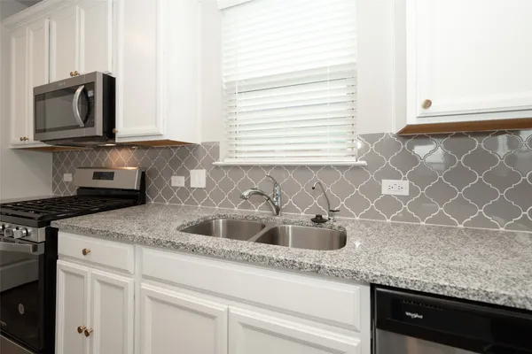 a kitchen with granite countertop a sink and a stove