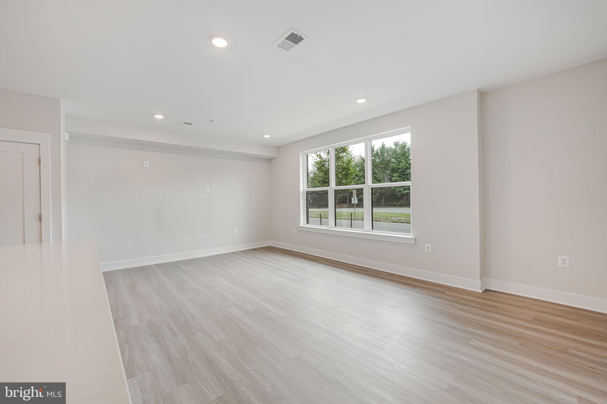 43795 Transit Square, Unit 101 Ashburn, VA 20147 - Photo 14 of 35 an empty room with wooden floor and windows