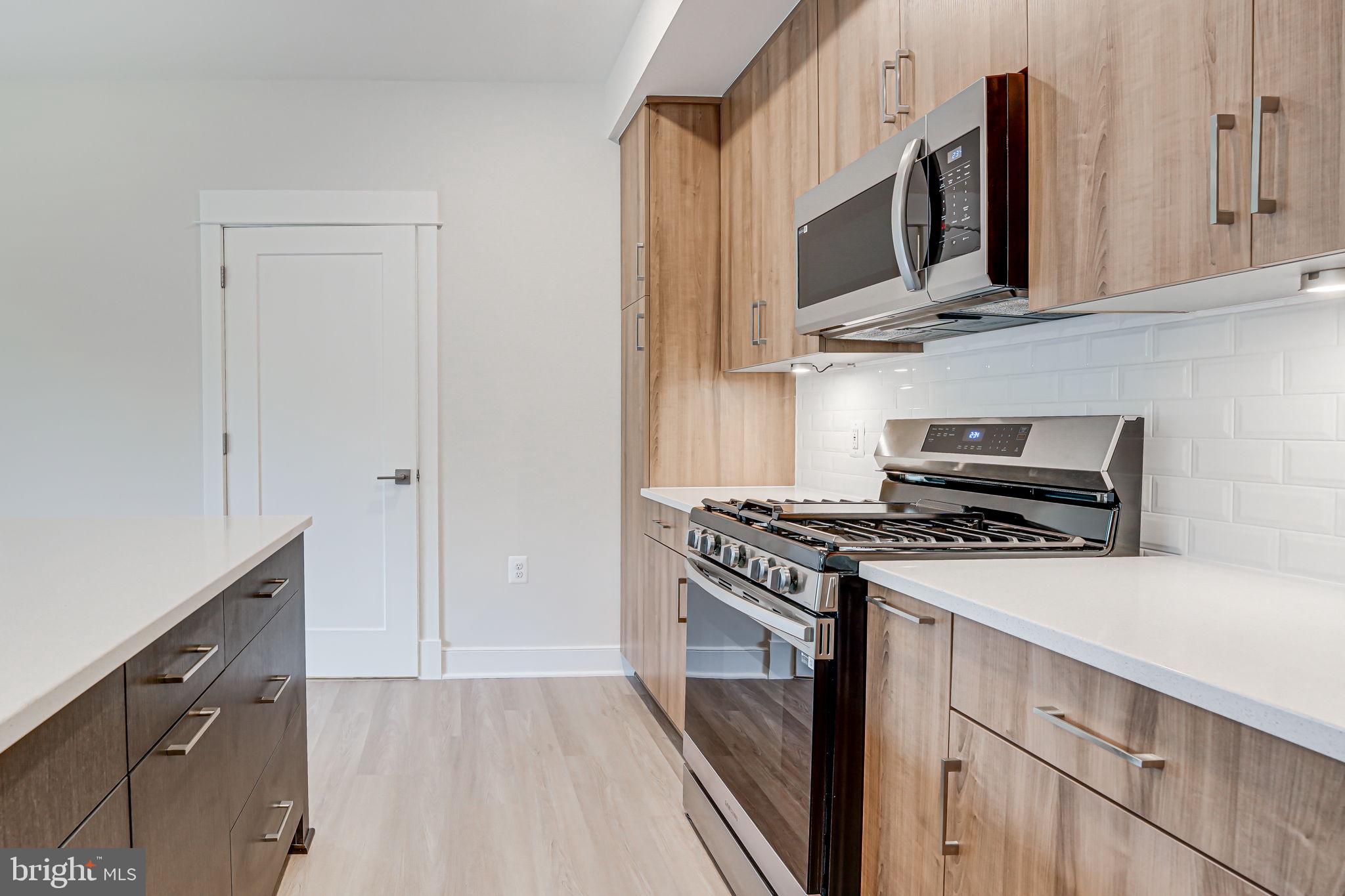 43795 Transit Square, Unit 101 Ashburn, VA 20147 - Photo 18 of 35 a kitchen with stainless steel appliances a stove a microwave and cabinets