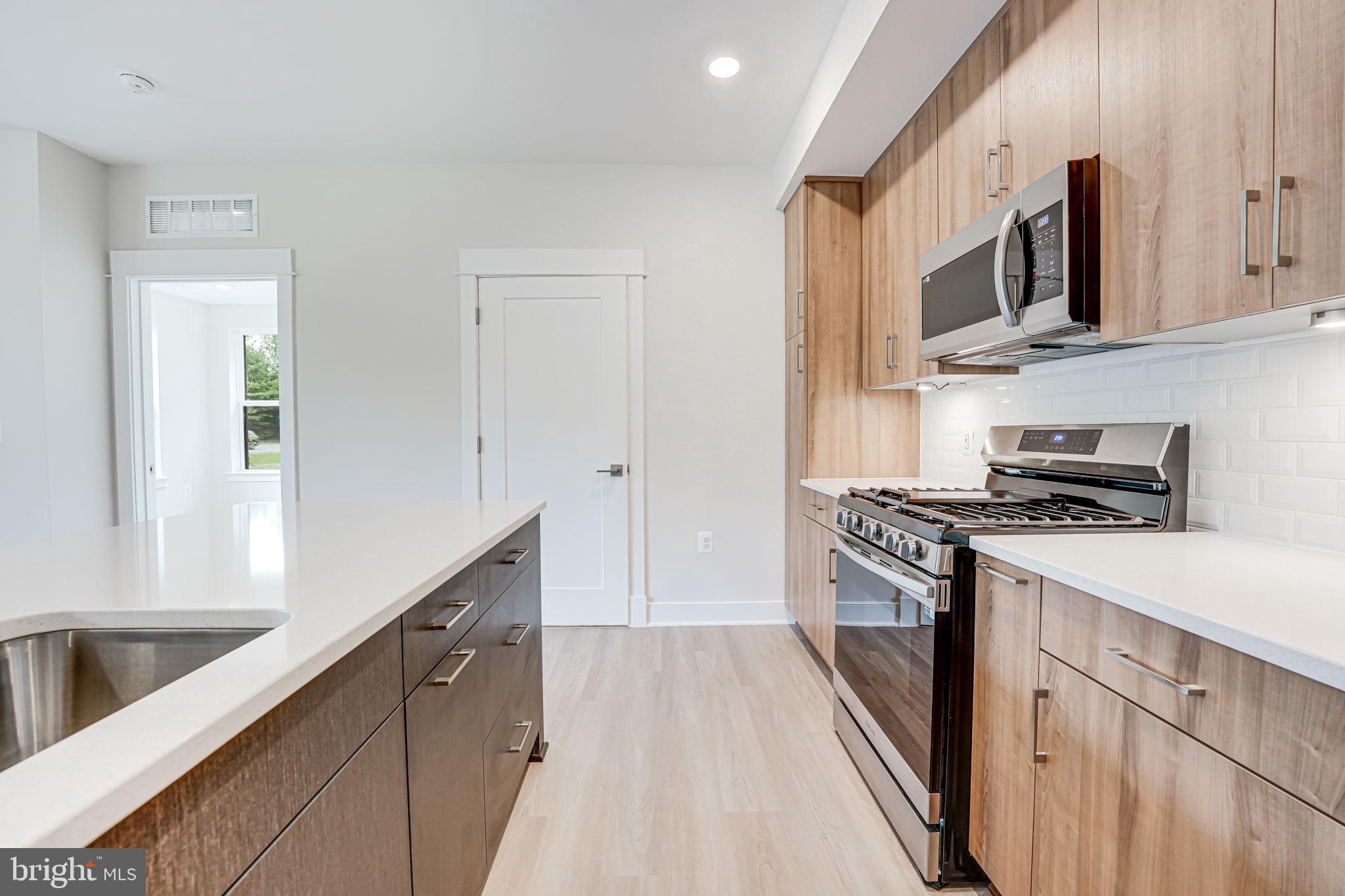 43795 Transit Square, Unit 101 Ashburn, VA 20147 - Photo 19 of 35 a kitchen with stainless steel appliances granite countertop a stove and a sink