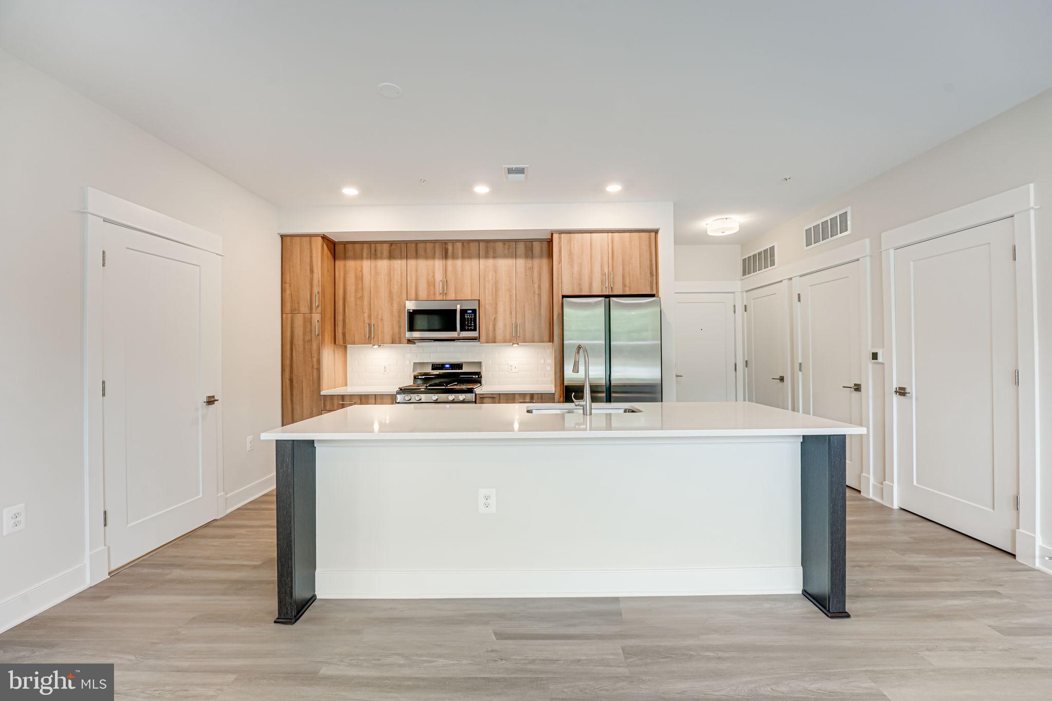 43795 Transit Square, Unit 101 Ashburn, VA 20147 - Photo 20 of 35 a view of kitchen with stainless steel appliances wooden floor and window