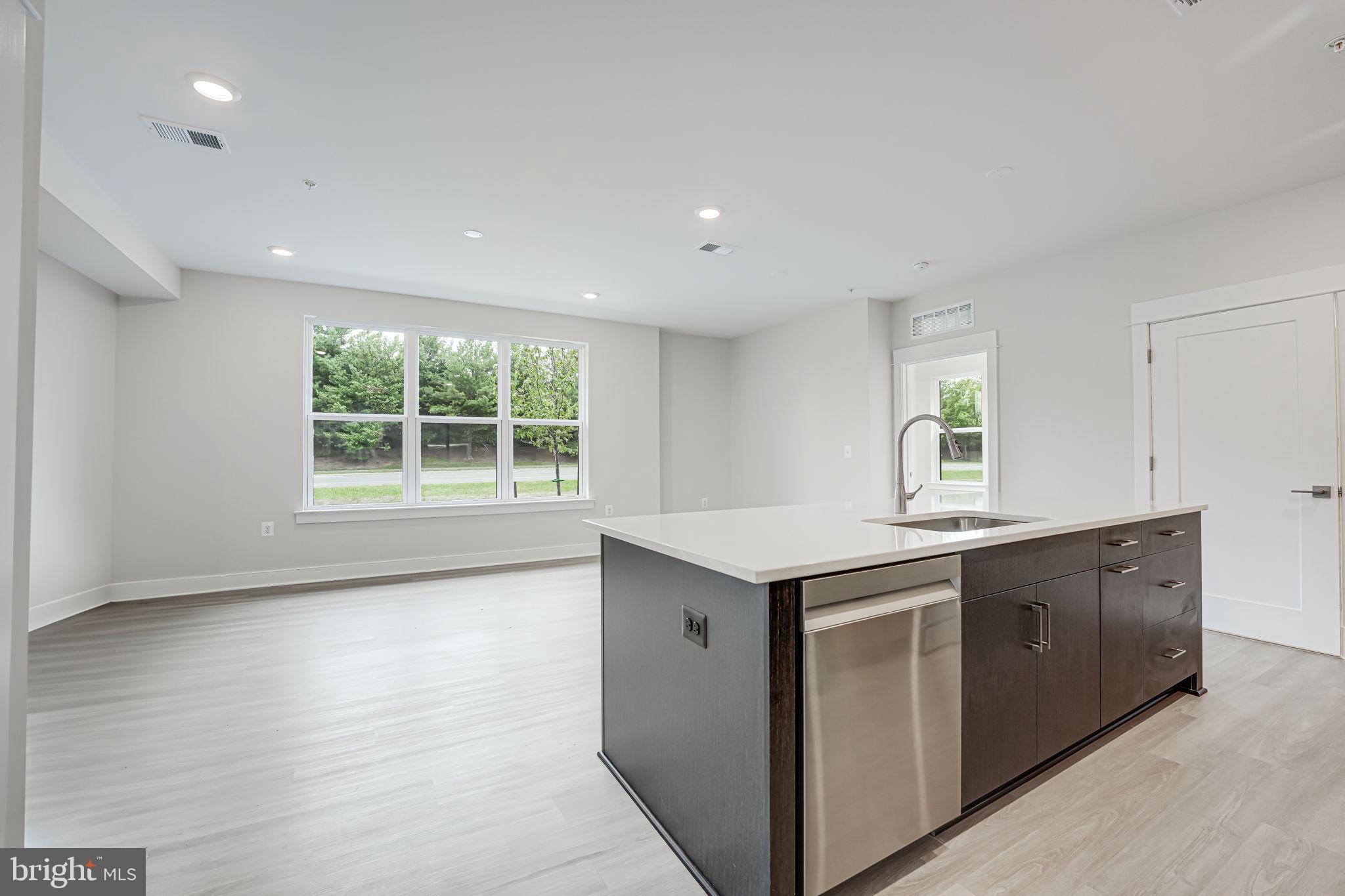 43795 Transit Square, Unit 101 Ashburn, VA 20147 - Photo 22 of 35 a living room with stainless steel appliances granite countertop a sink and a large window