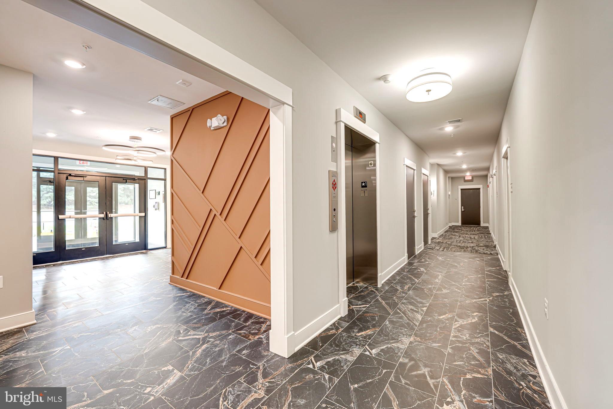 43795 Transit Square, Unit 101 Ashburn, VA 20147 - Photo 4 of 35 a view of a hallway with wooden floor and entryway