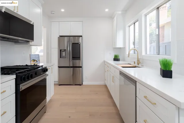 a kitchen with stainless steel appliances a sink stove and refrigerator