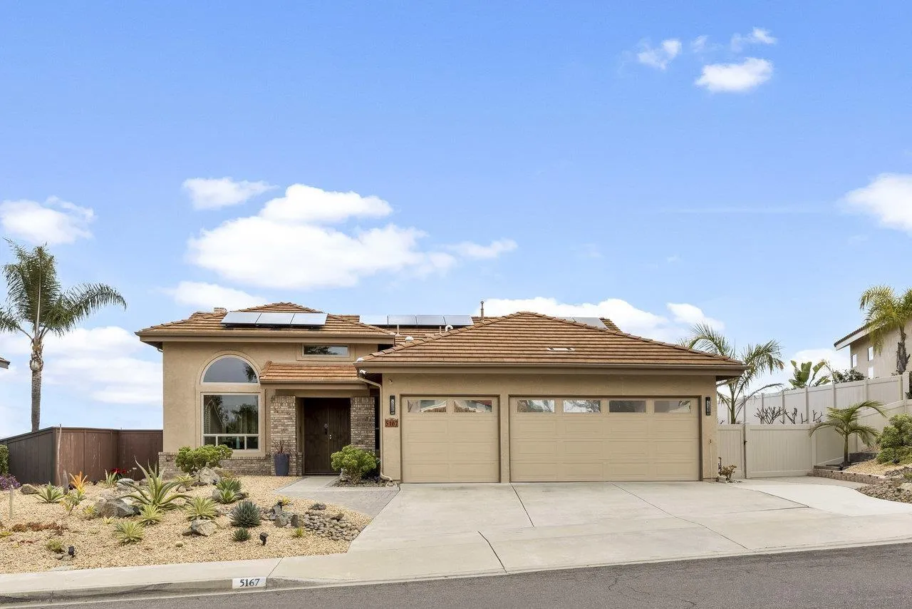 a view of a white house with a large windows and a pathway