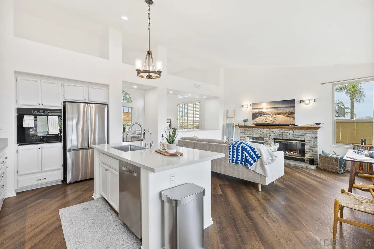 5167 Avenida De La Plata Oceanside, CA 92057 - Photo 16 of 53 a kitchen with stainless steel appliances granite countertop a stove refrigerator and couches with wooden floor