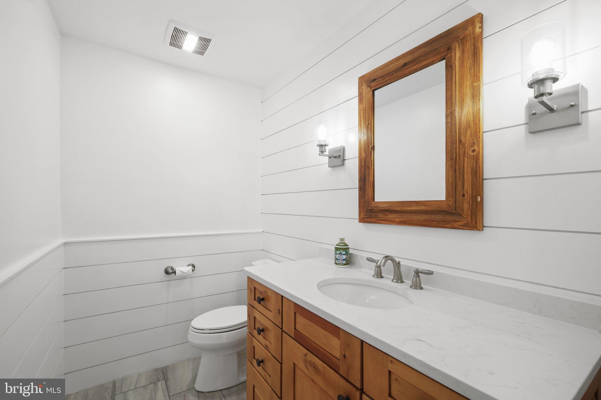 11005 Luxmanor Road North Bethesda, MD 20852 - Photo 17 of 49 a bathroom with a granite countertop toilet sink and mirror