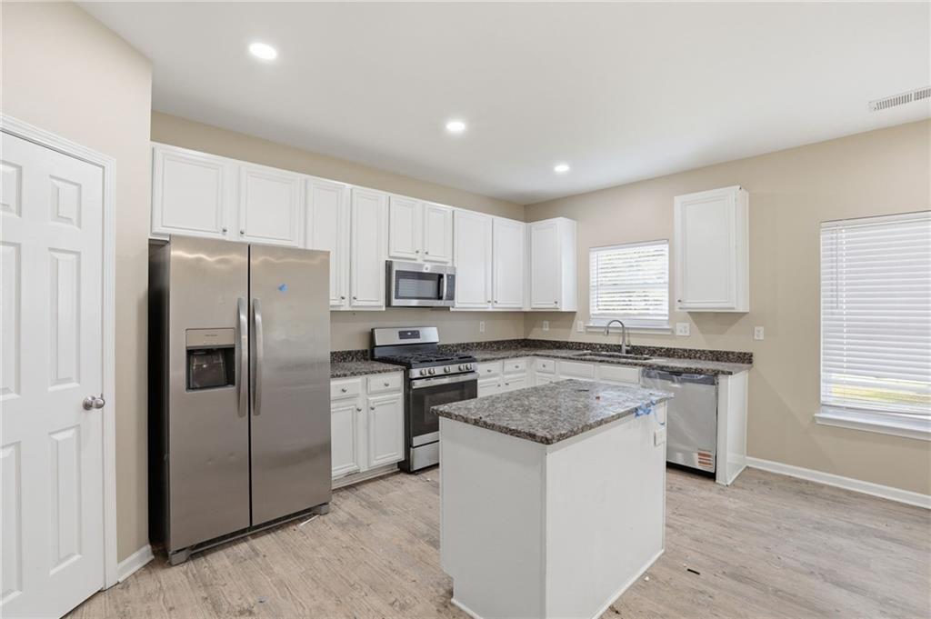 4968 Locherby Drive Fairburn, GA 30213 - Photo 16 of 39 a kitchen with stainless steel appliances granite countertop a stove a refrigerator and a sink