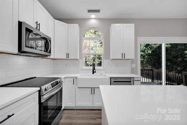 a kitchen with a stove a sink and a microwave