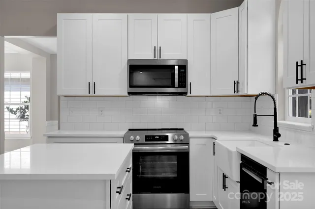 a kitchen with stainless steel appliances a stove a microwave and sink