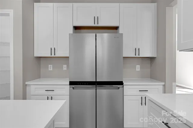 a kitchen with a refrigerator a sink and cabinets