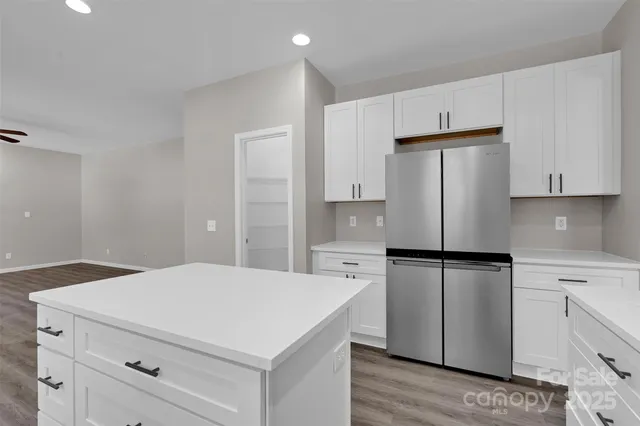 a kitchen with refrigerator cabinets and wooden floor