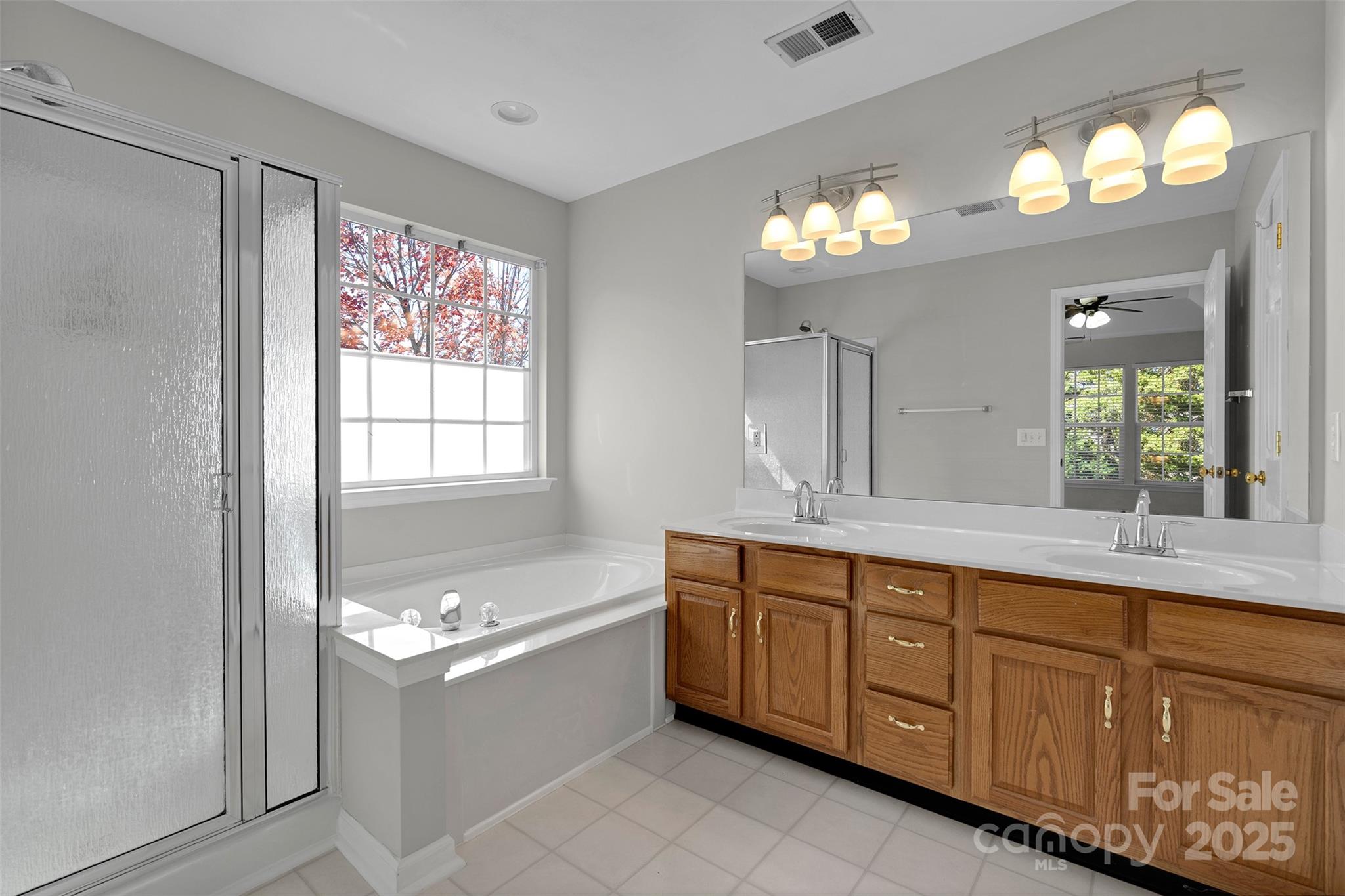 9211 Hickory Tree Lane Charlotte, NC 28277 - Photo 30 of 46 a spacious bathroom with a granite countertop tub a sink and a large mirror