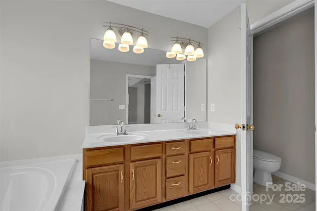 a bathroom with a granite countertop sink a toilet and a mirror