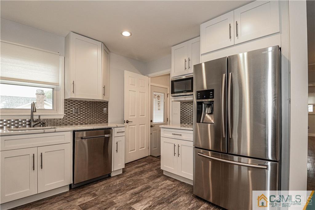 a kitchen with stainless steel appliances a refrigerator sink and cabinets