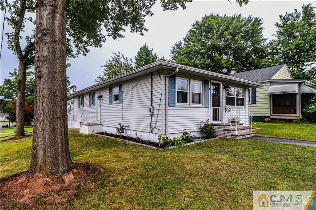 578 Chain O' Hills Road Colonia, NJ 07067 - Photo 36 of 39 a view of a house with a yard and lawn chairs under a large tree