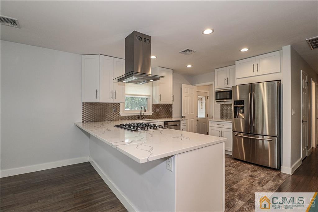 578 Chain O' Hills Road Colonia, NJ 07067 - Photo 9 of 39 a kitchen with a stove a refrigerator and wooden floor