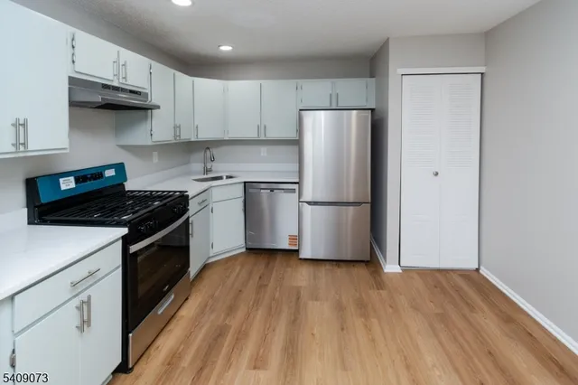 a kitchen with a refrigerator and a stove top oven