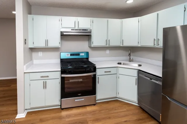 a kitchen with cabinets appliances and a counter space