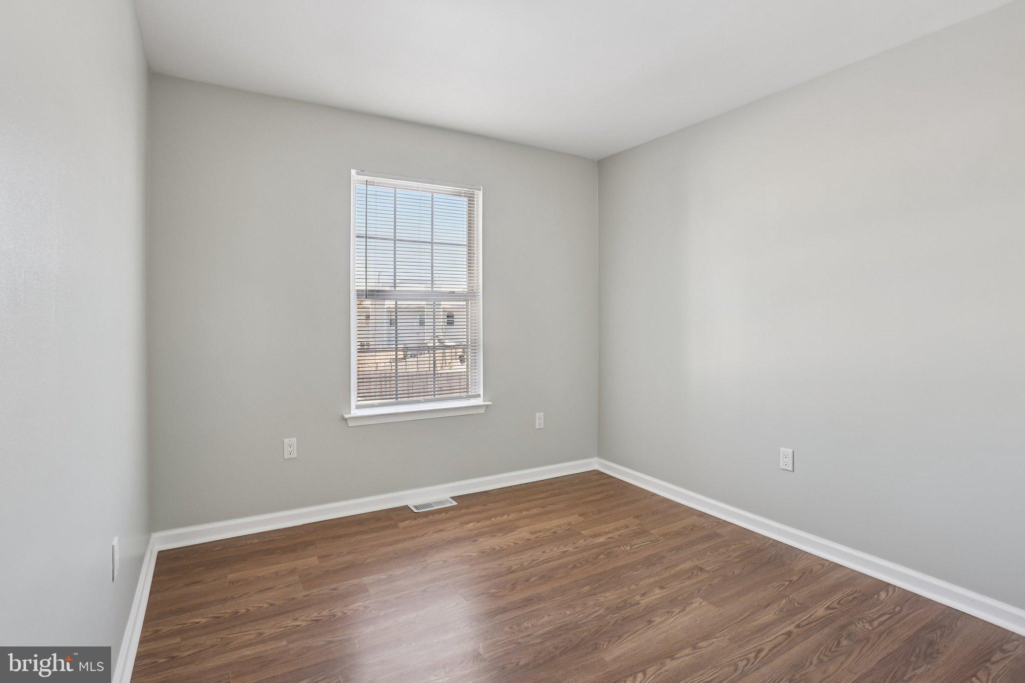 110 Auckland Drive Newark, DE 19702 - Photo 22 of 30 an empty room with wooden floor and windows