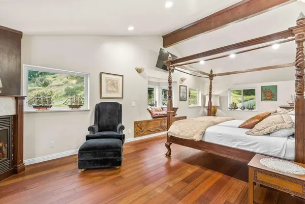 a bedroom with a bed window and a chair