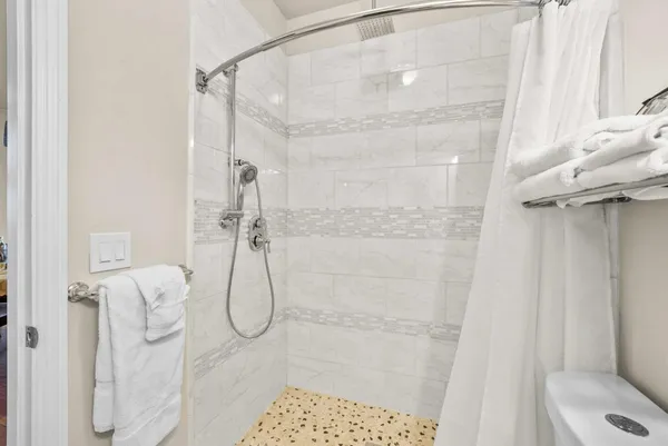 a bathroom with a sink a toilet and shower