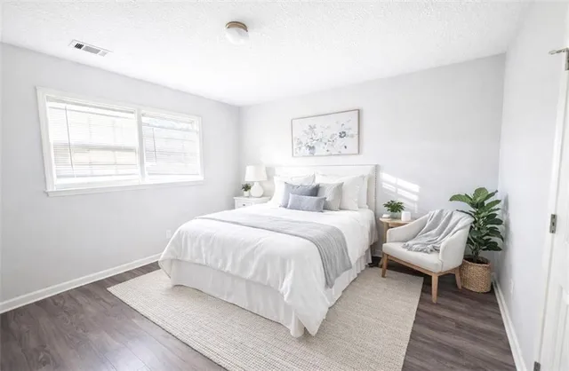 a bedroom with a bed and a potted plant