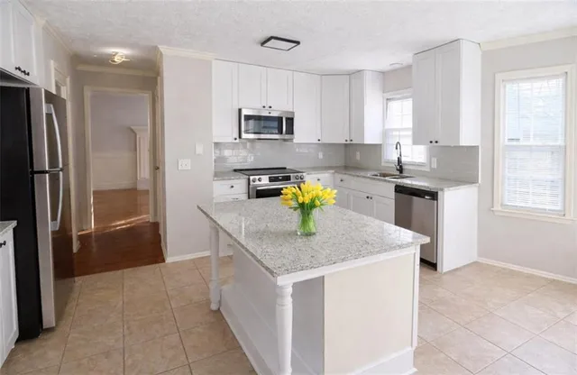 a kitchen with stainless steel appliances granite countertop a refrigerator a stove top oven a sink and dishwasher