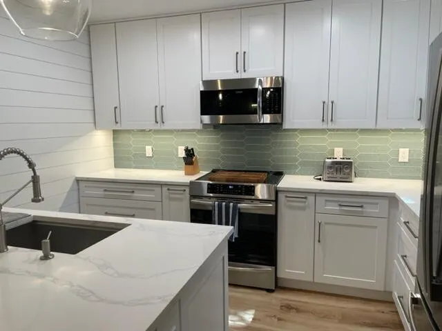 a kitchen with stainless steel appliances granite countertop a sink stove and microwave