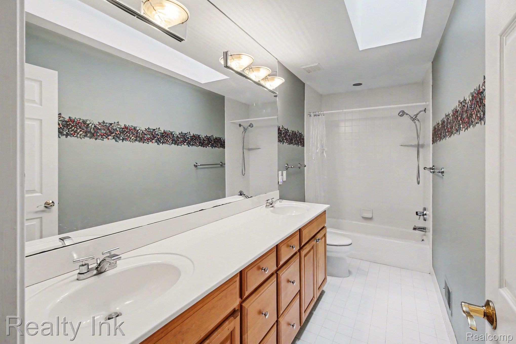 4927 Nature View Court Howell, MI 48843 - Photo 14 of 19 Bathroom featuring double vanity, shower / bath combo, and a skylight