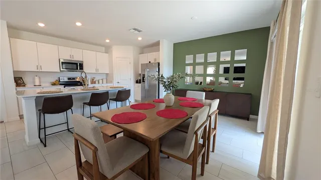 a living room with furniture a flat screen tv and kitchen view