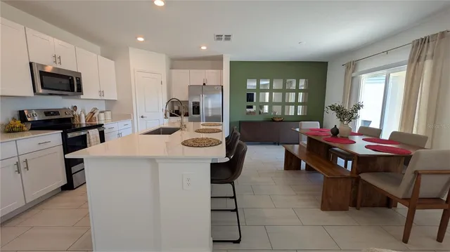 a kitchen with stainless steel appliances a table and chairs