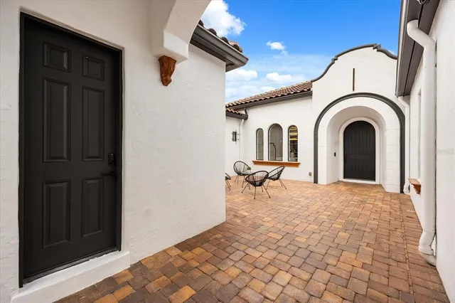 a living room with furniture large window and wooden floor